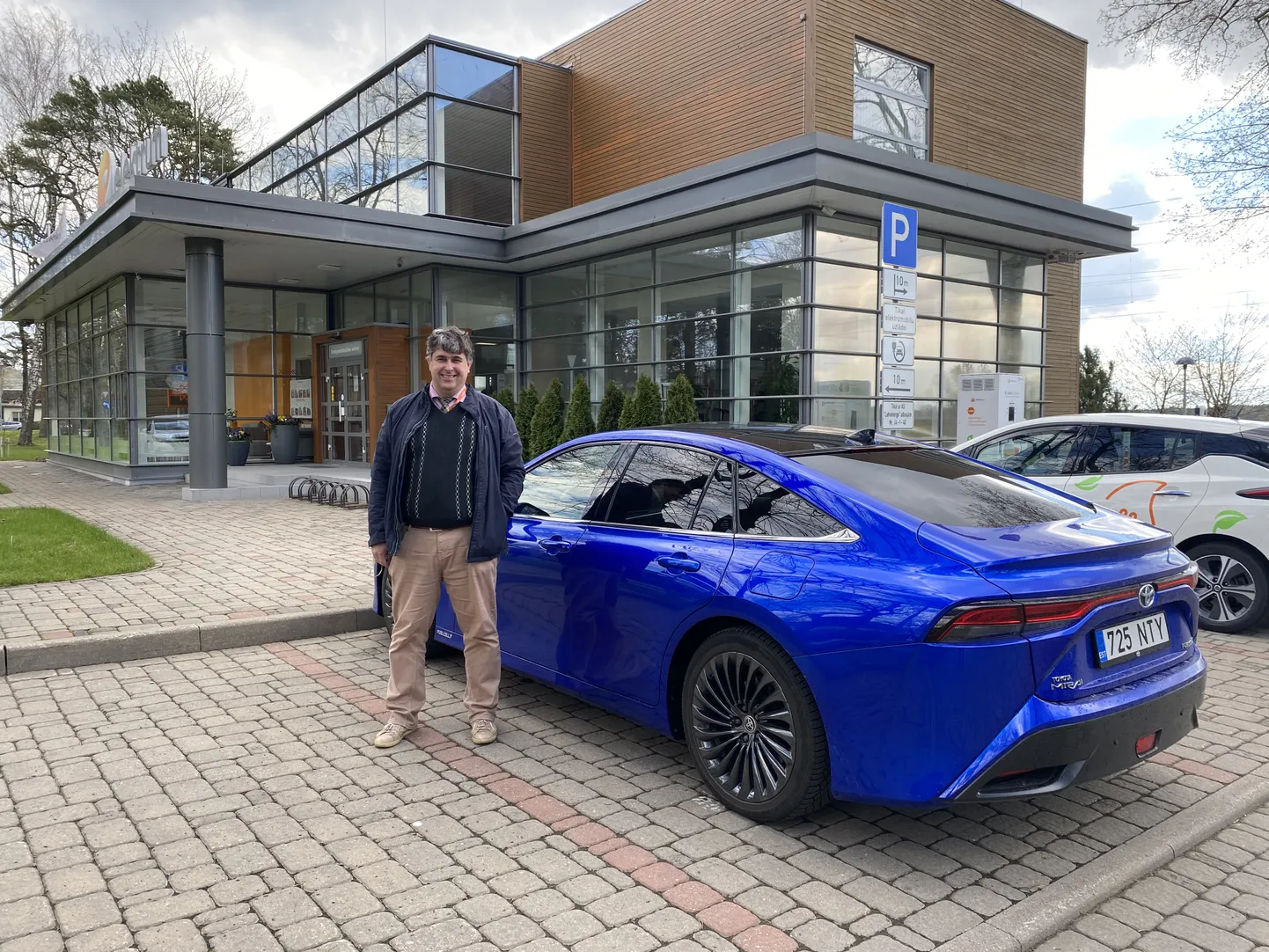 Oļegs Linkevičs - foto pie Elektrum Energoefektivitātes centra līdzās ūdeņraža degvielas šūnu auto un elektriskajam auto