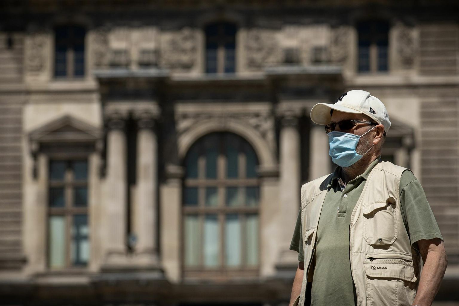Näomaskis mees Pariisis Louvre’i muuseumi juures. Prantsusmaa valitsus soovitab rahvarohketes kohtades kanda maski, kuid kohustuslikuks seda teha ei soovi. 