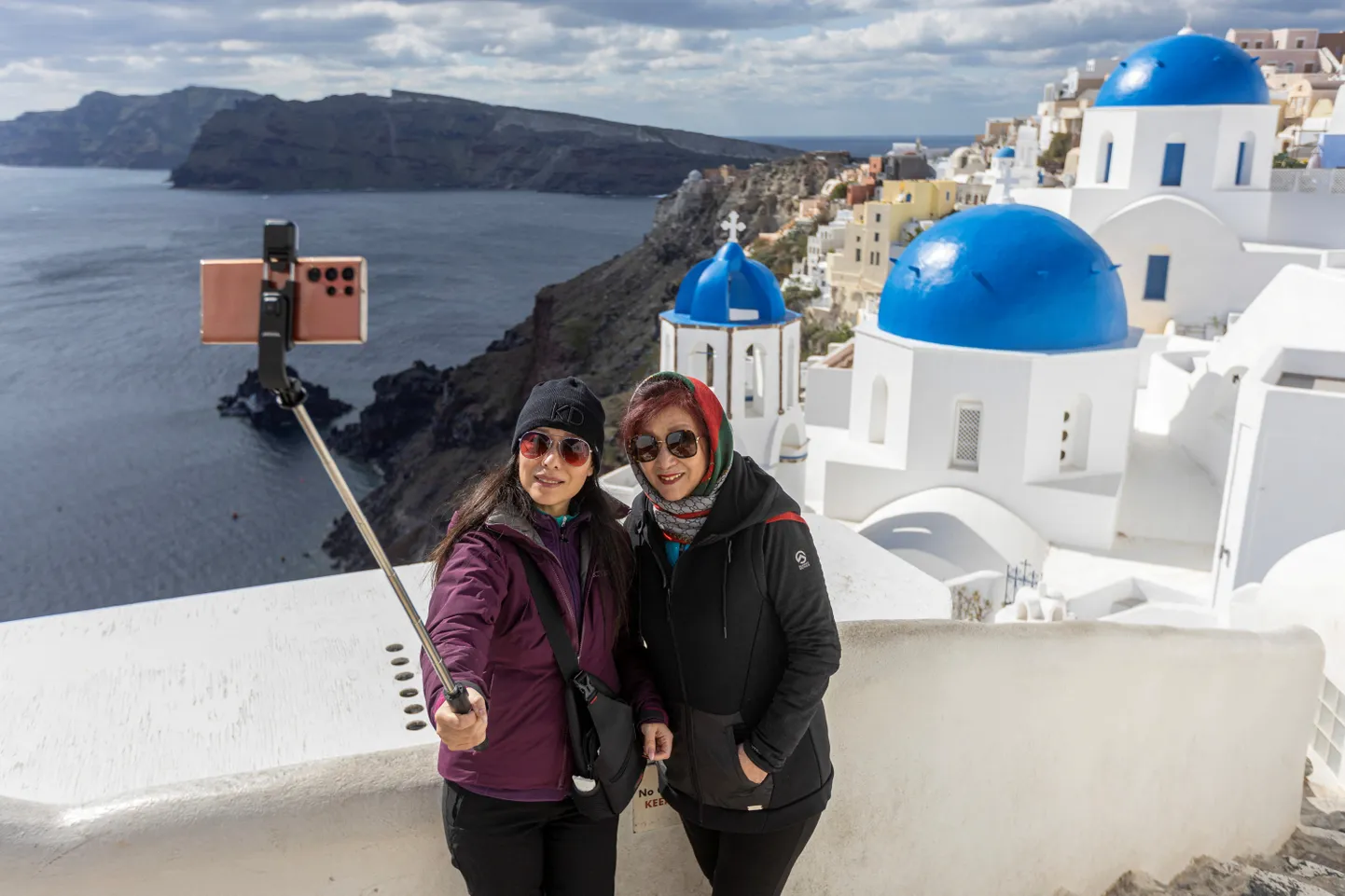 Tūristi uzņem selfiju Oijas ciematā, turpinoties seismiskajai aktivitātei, Santorini salā, Grieķijā, 2025. gada 22. februārī.