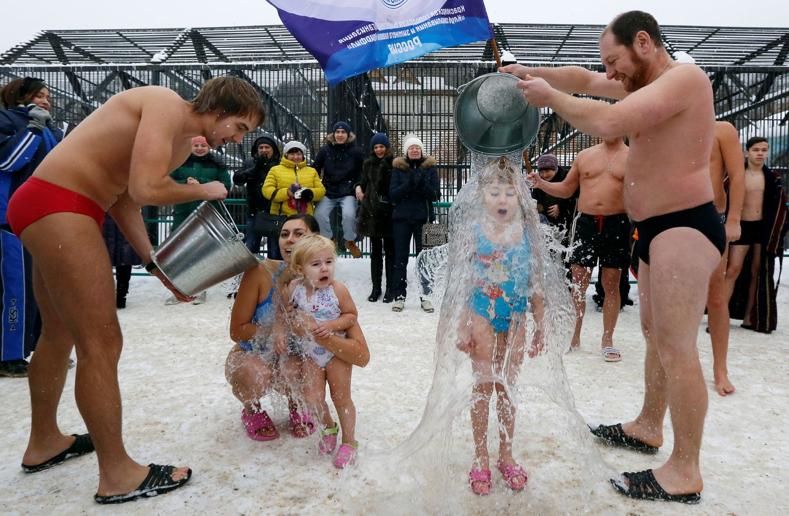 Vietējā ziemas peldēšanas komanda aplej ar ūdeni savus bērnus Polārlāču aizsardzības dienas pasākumā Krasnojarskā, Krievijā.
