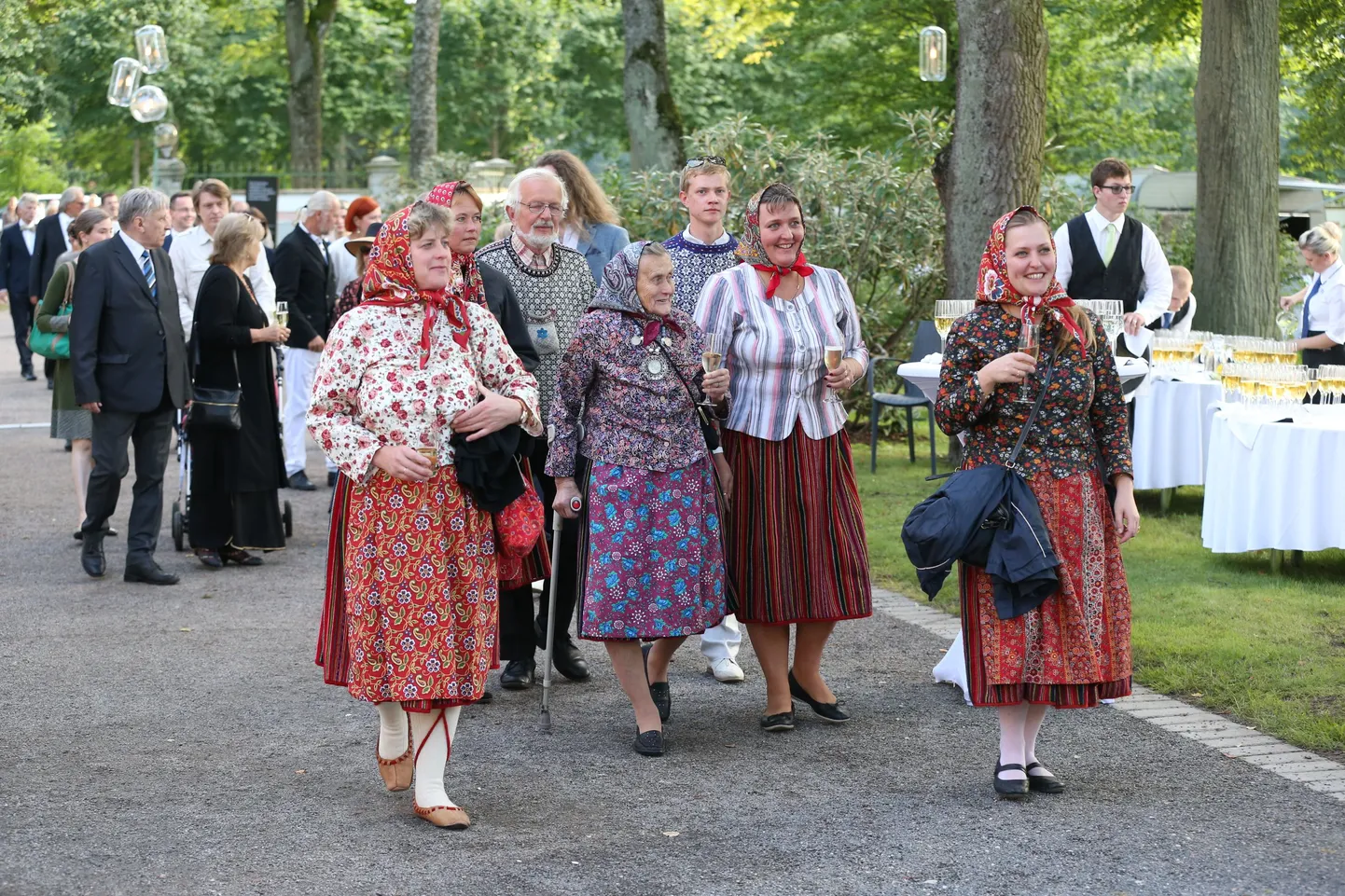 Virve Köster oma pereansambli liiklmetega ja Manija esindajad Mark Soosaar ning Svea Aavik suunduvad presidendi roosiaeda.