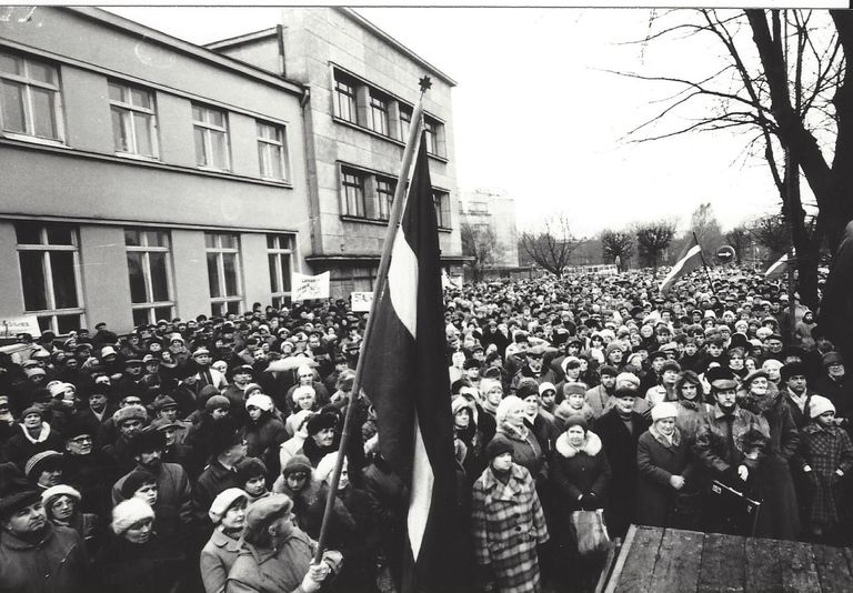 1988. gada 26. novembris Liepāja, Rožu laukums, mītiņš “Par tiesisku valsti”. Priekšplānā - vīrietis ar Latvijas karogu.