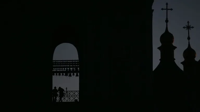 Темные силуэты церквей на фоне ночного неба.