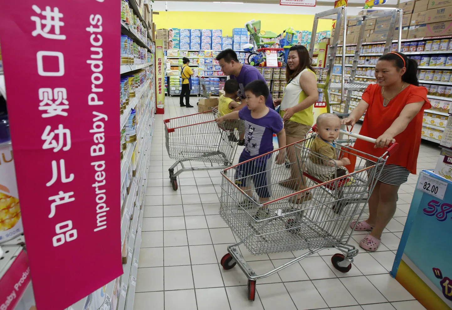 Hiina perekond Pekingi supermarketis lastetoidu riiuleid uurimas.