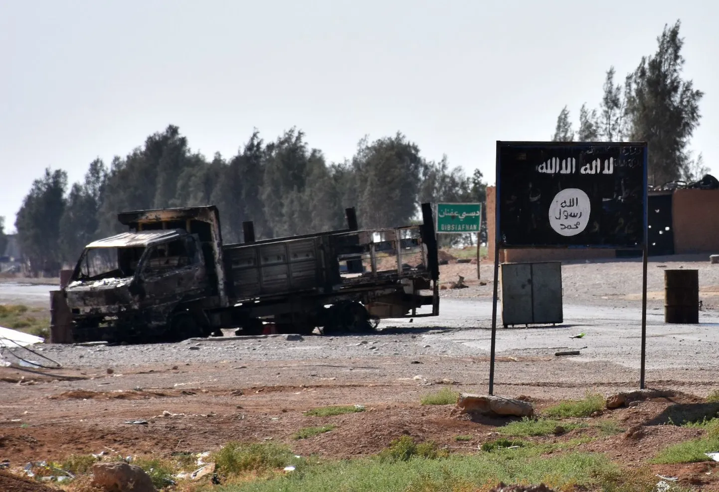 Põlenud sõiduk Islamiriigi lipu kõrval Dibsiafnani külas.