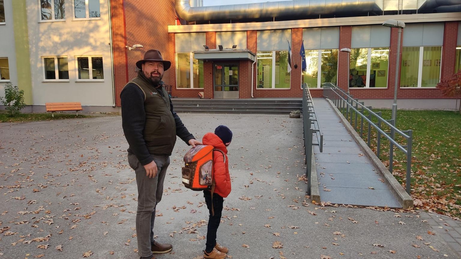 Pereisa Herko Sunts ja tema noorem poeg, ranits ilusti seljas, eile hommikul enne tundide algust Tartu Hiie kooli ees.