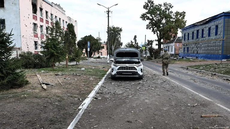 Солдат ВСУ в Судже на фоне разрушений в ходе боевых действий