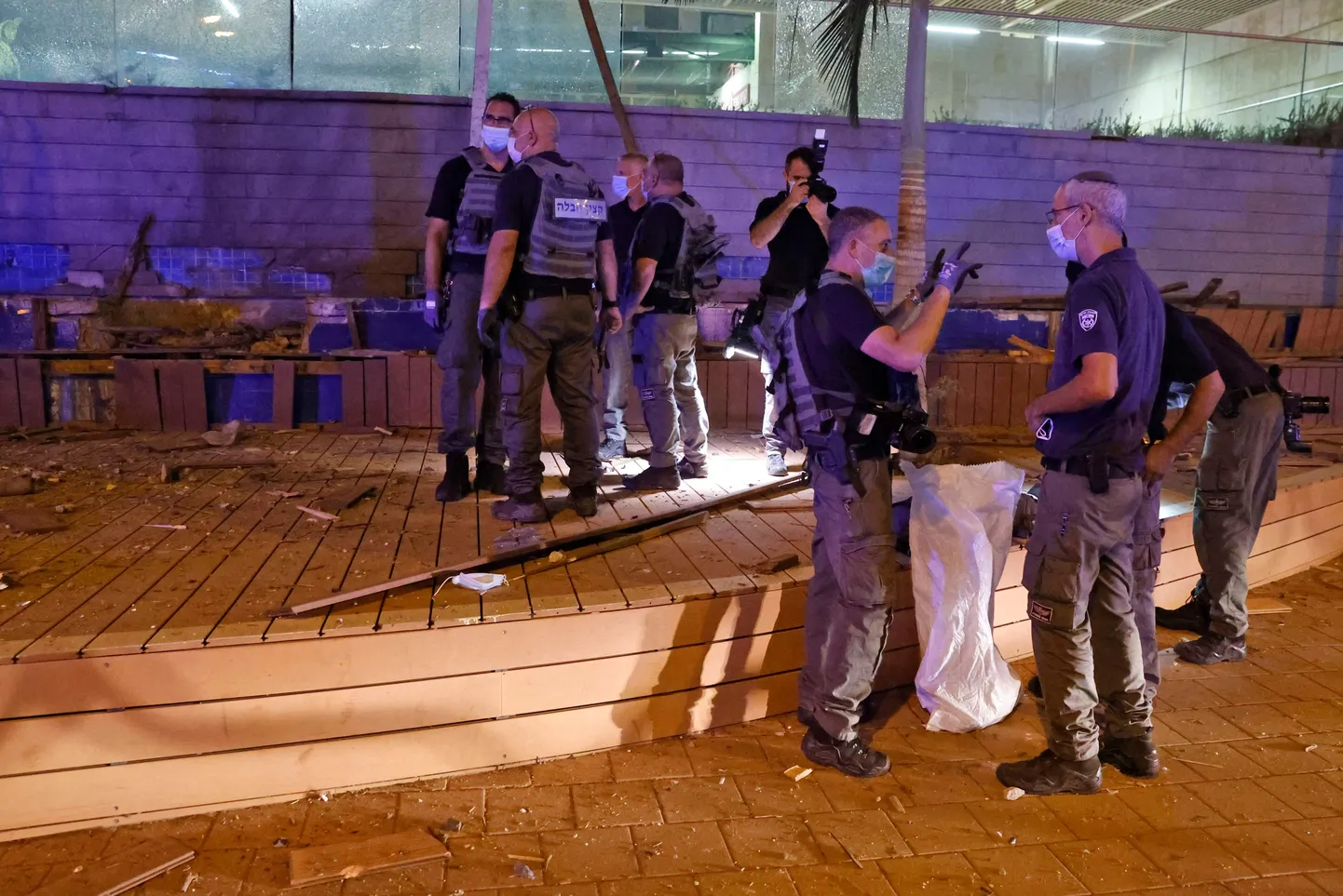 Izraēlas drošībnieki strādā vietā, kur nokritusi no Gazas joslas izšauta raķete