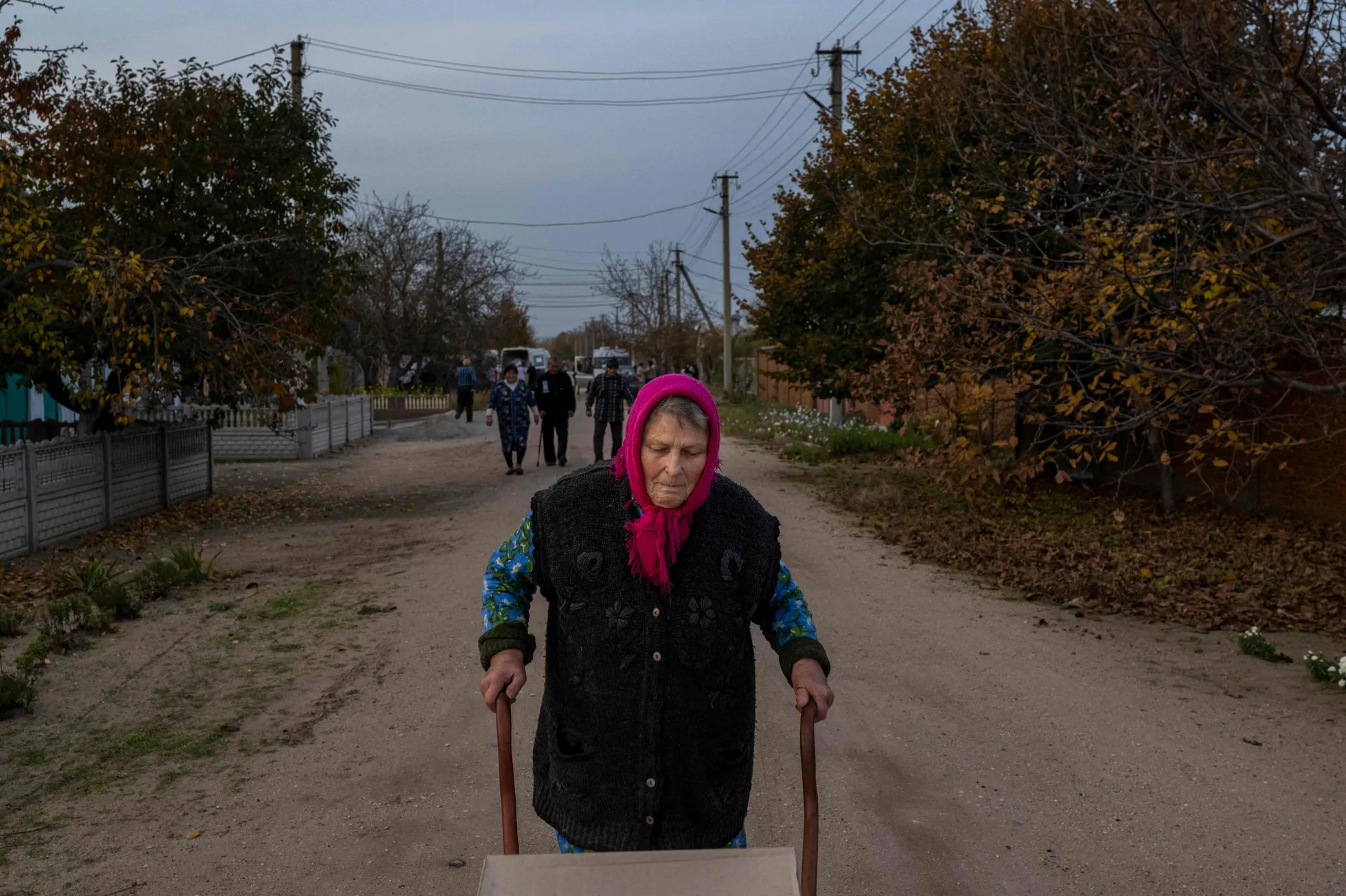 Eakas naine veeretab Lõmanõ külas käruga koju karpi humanitaarabiga.