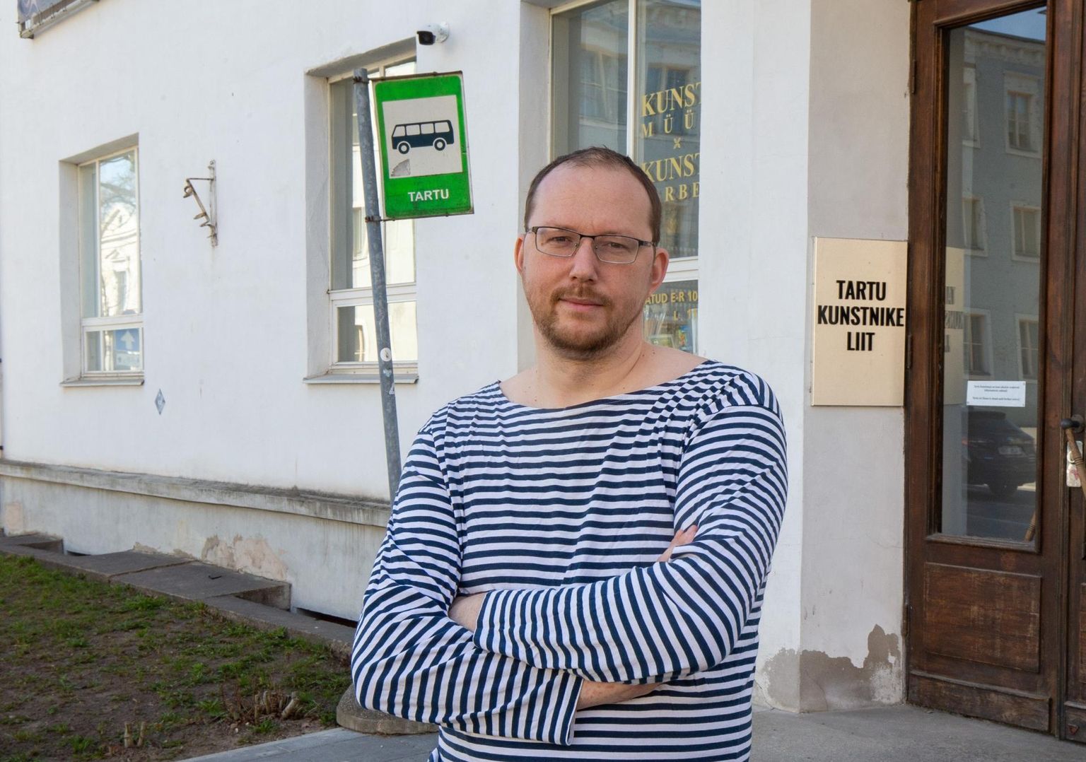 Peeter Talvistu seisab kunstimaja ees ja seisab ka Tartu kunstnike eest.