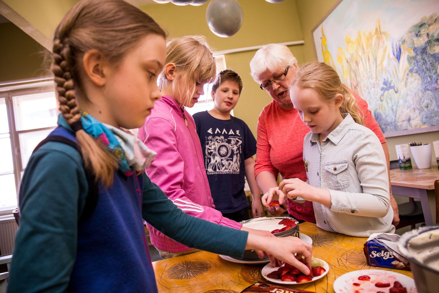 Tõsiselt asja juures: emadepäeva küpsisetordile laovad maasikaviile (vasakult) Rahe, Triin, Erik, kondiiter Nadja Kaarma ja Säde.