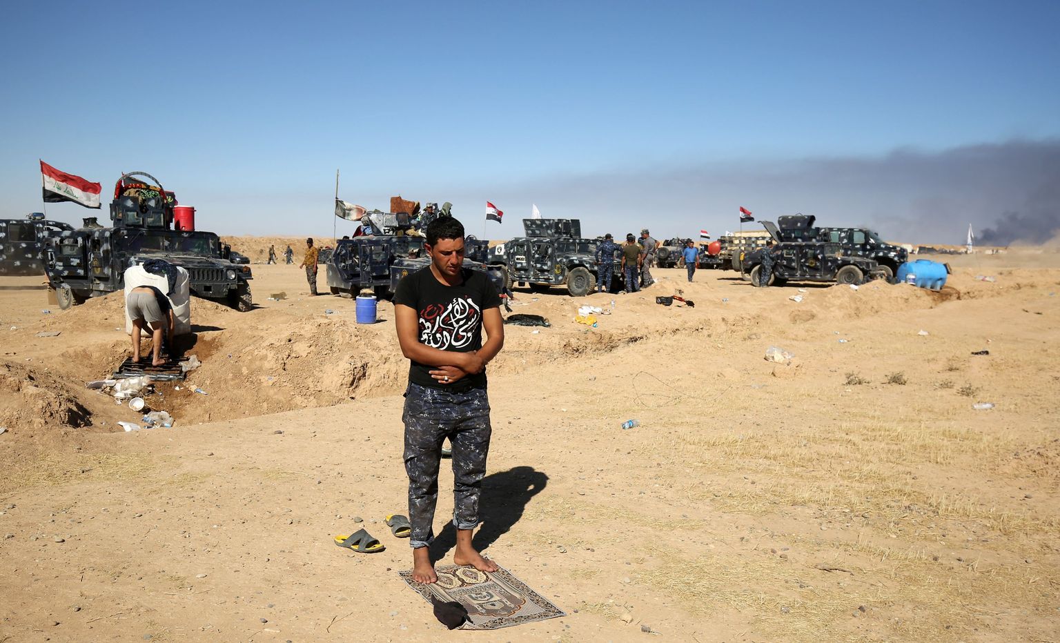 A Sunni Iraqi policeman prays at the Qayyarah military base, about 60 kilometres (35 miles) south of Mosul, on October 16, 2016, as they prepare for an offensive to retake Mosul, the last IS-held city in the country, after regaining much of the territory the jihadists seized in 2014 and 2015. / AFP PHOTO / AHMAD AL-RUBAYE