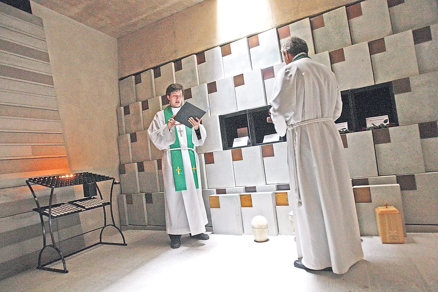 Tartu Pauluse koguduse abiõpetaja Kristjan Luhamets (vasakul) ja õpetaja Joel Luhamets panid eile hommikul kiriku keldris krüpti esimesed viis urni.