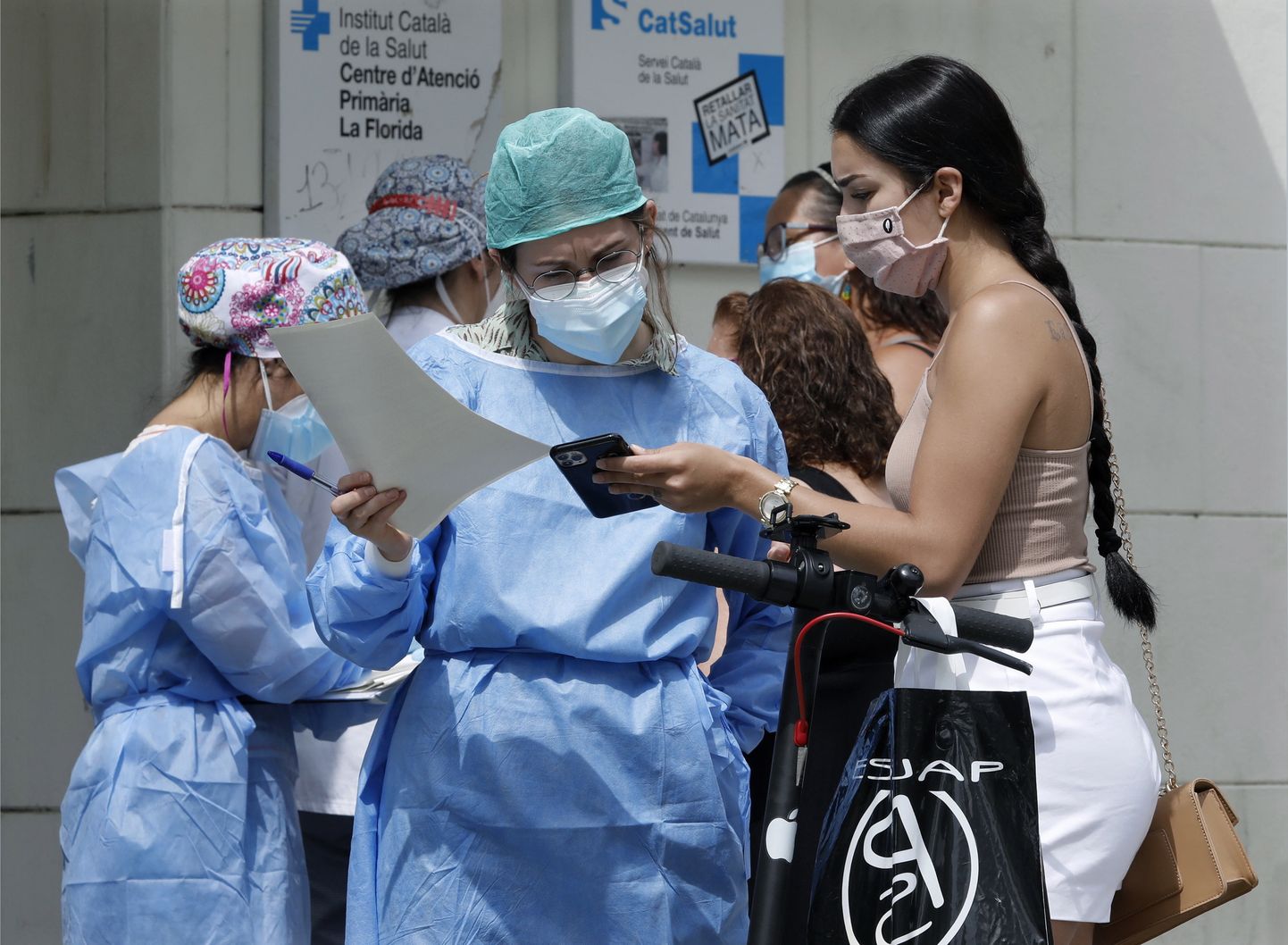 Õde kontrollimas patsiendi vastuvõtuaega ühe Barcelona kliiniku ees.