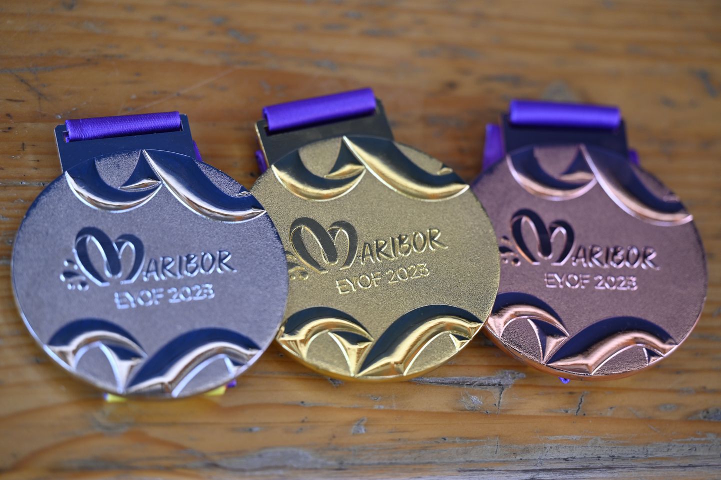 На фото изображены серебряная, золотая и бронзовая медали в толкании ядра в последний день Европейского юношеского летнего олимпийского фестиваля 2023 года в Мариборе, Словения.