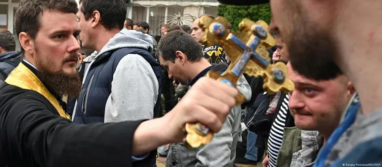 Vene õigeusu vaimulik ja Vene armeesse mobiliseeritud mehed.