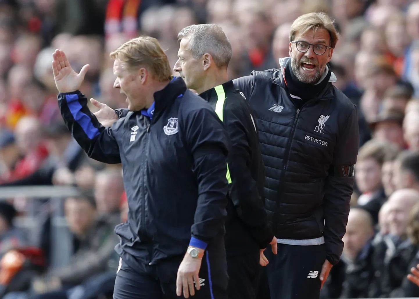 Liverpooli peatreener Jürgen Klopp (paremal) vaidlemas eilses kohtumises Evertoni lootsi Ronald Koemaniga. Keskel mängu neljas kohtunik Martin Atkinson.