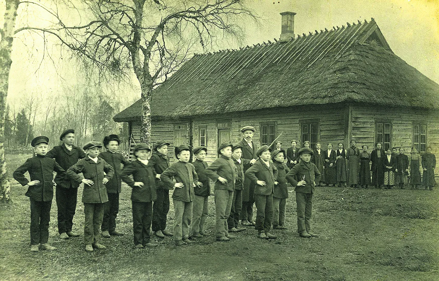 GIMNASTIKA TUND Pilguse koolimaja ees 1914. aastal. Kui poisid võimlesid, vaatasid tüdrukud pealt. Õpetaja hoiab käes vitsa.