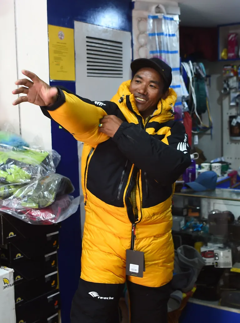 Nepali šerpa Kami Rita proovimas Katmandu mägironimsvarustuse poes ronimiskobinesooni selga