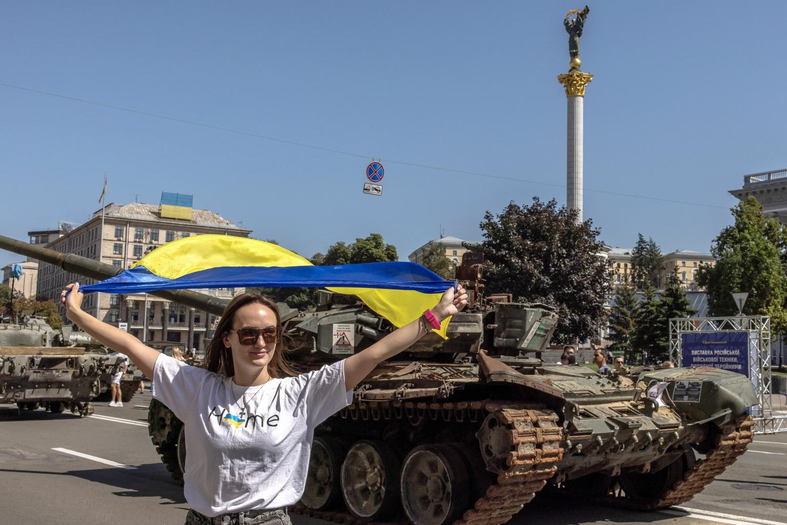 Ukraina lipuga naine poseeris eilsel iseseisvuspäeval Kiievi kesklinnas, kuhu on välja pandud purustatud Vene sõjatehnika.