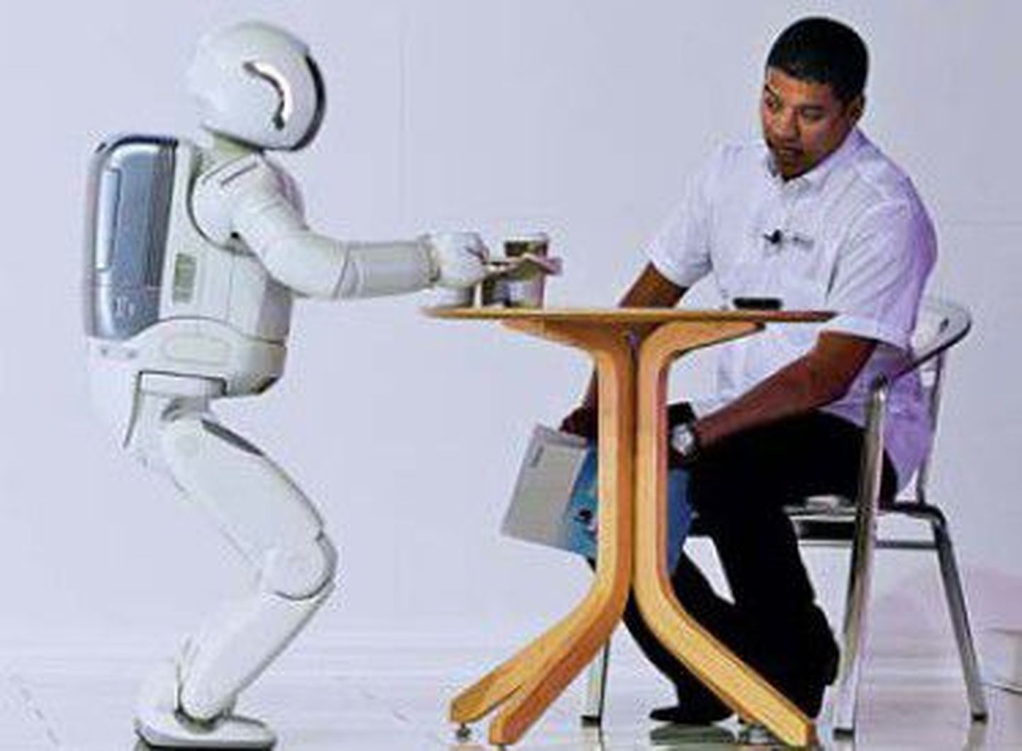 Робот Асимо производства компании Хонда сервирует чай на выставке в Йоханнесбурге.