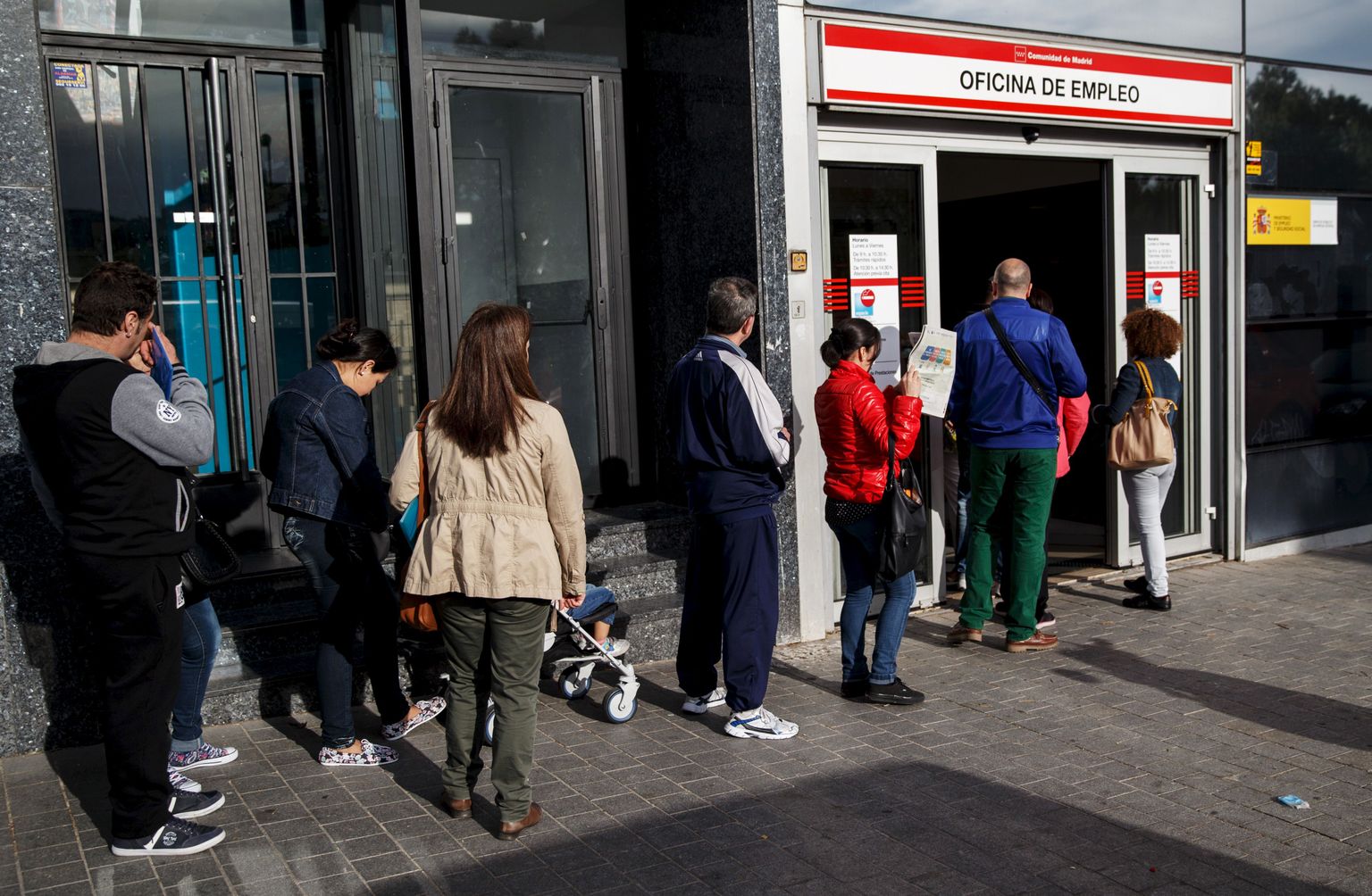 People stand in a line to enter a government employment office in Madrid, Spain, May 5, 2015. The number of Spaniards registered as jobless fell by 2.7 percent in April from a month earlier, the sharpest fall in a month of April on record, data from the Labour Ministry showed on Tuesday, but one in four remain unemployed.  REUTERS/Andrea Comas