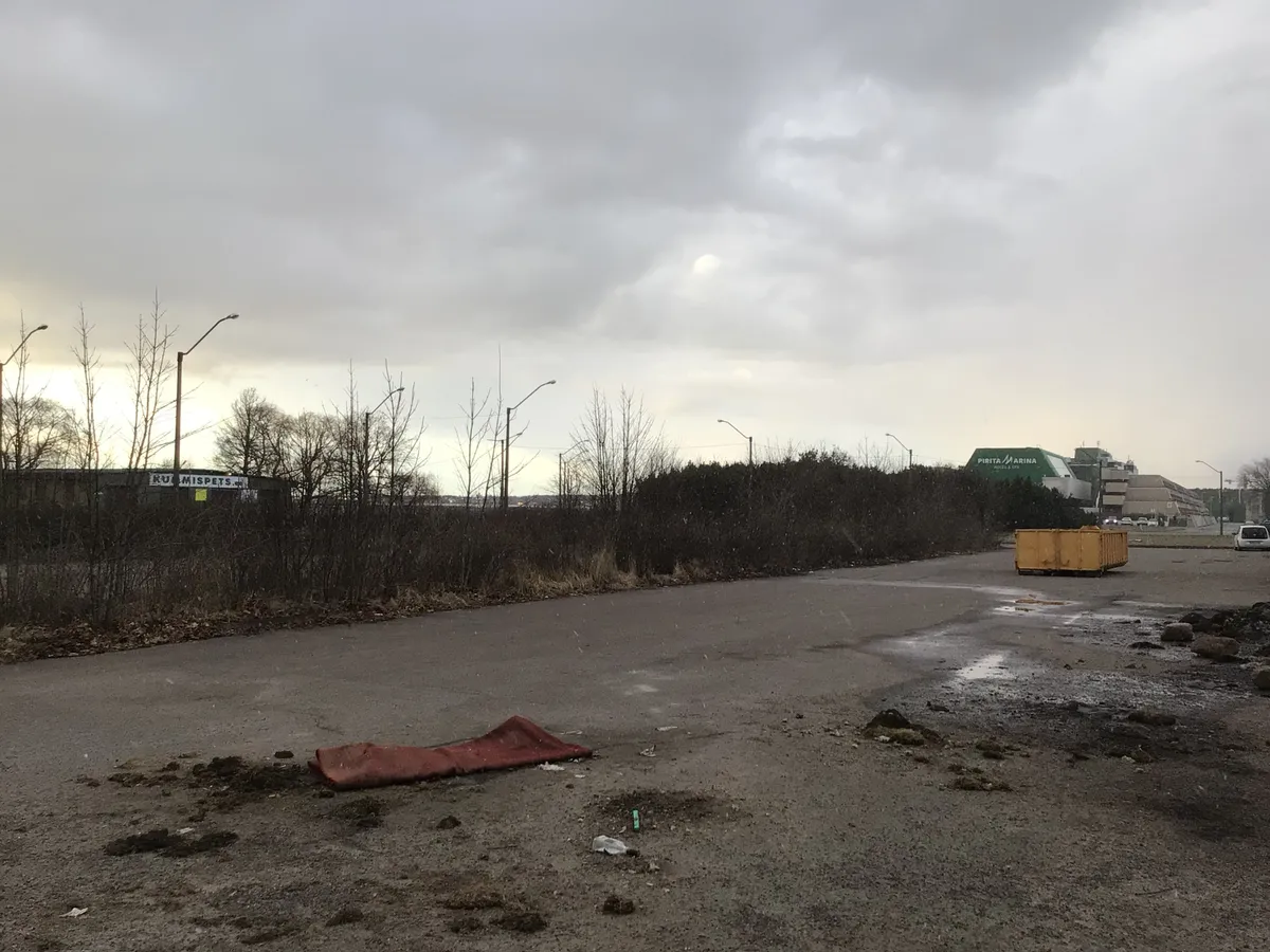 Võsastunud parkla Pirita tee ääres. Taamal paistab Pirita TOPi hotell ja väidetavalt Tallinna parima vaatega rehvitöökoda.