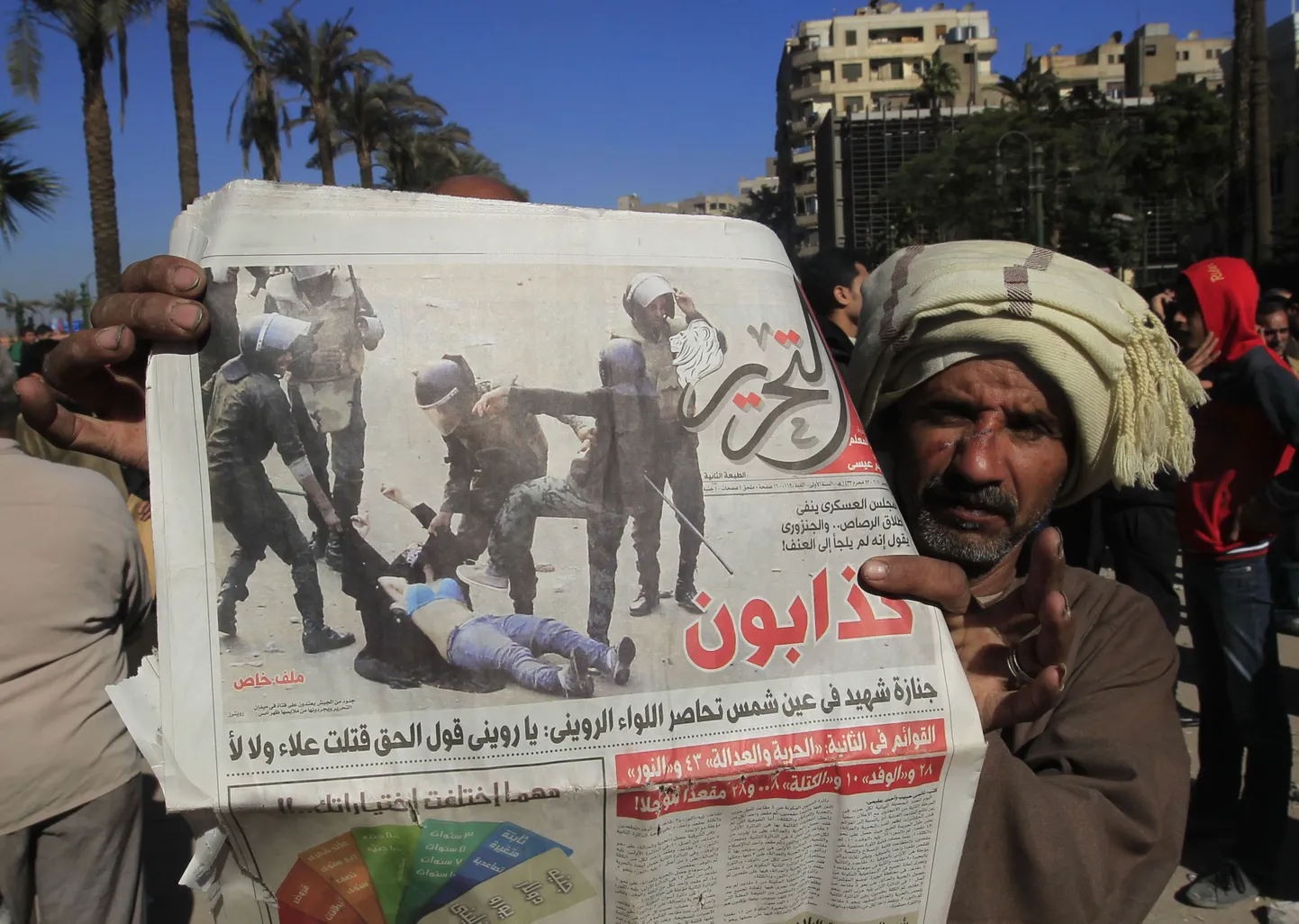 Egiptlane näitab kohaliku ajalehe fotot julgeolekujõududest peksmas maas lebavat naissoost meeleavaldajat.