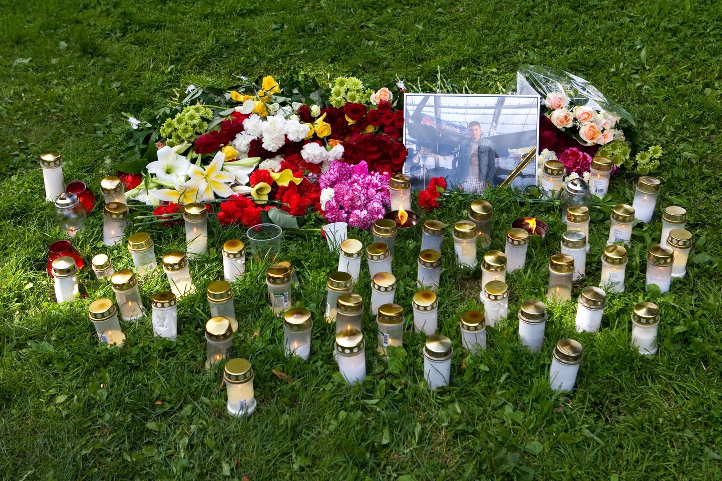 Tammsaare pargis tapetud noormehe sõbrad on sinna toonud hulga küünlaid ja lilli.