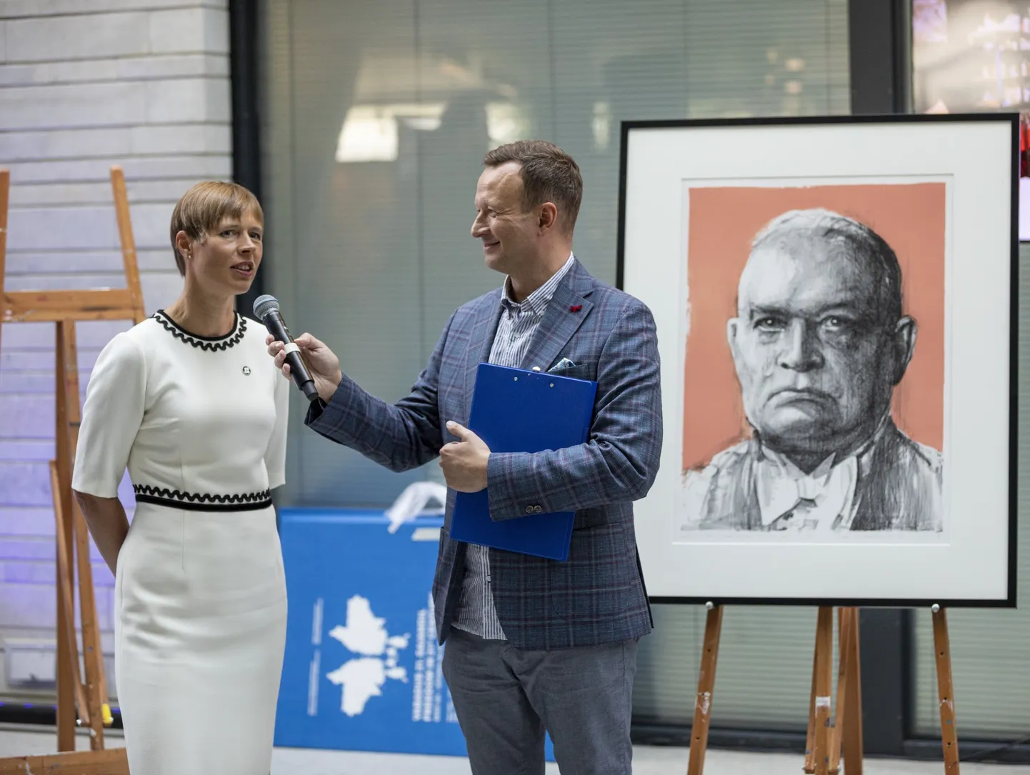 Hetk esitluselt. Taustal üks kogumikku kuuluv teos: Laurentsius – President Päts pisaraga