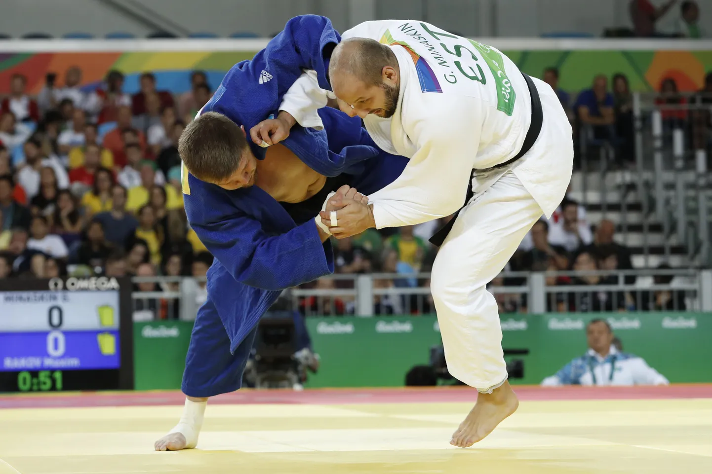 Estonia's Grigori Minaskin (white) competes with Kazakhstan's Maxim Rakov during their men's -100kg judo contest match of the Rio 2016 Olympic Games in Rio de Janeiro on August 11, 2016. / AFP PHOTO / Jack GUEZ