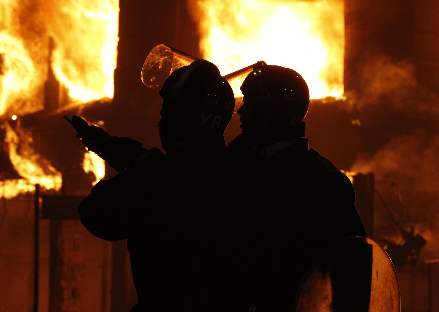 Märulipolitseinikud põleva maja ees Tottenhamis Põhja-Londonis.