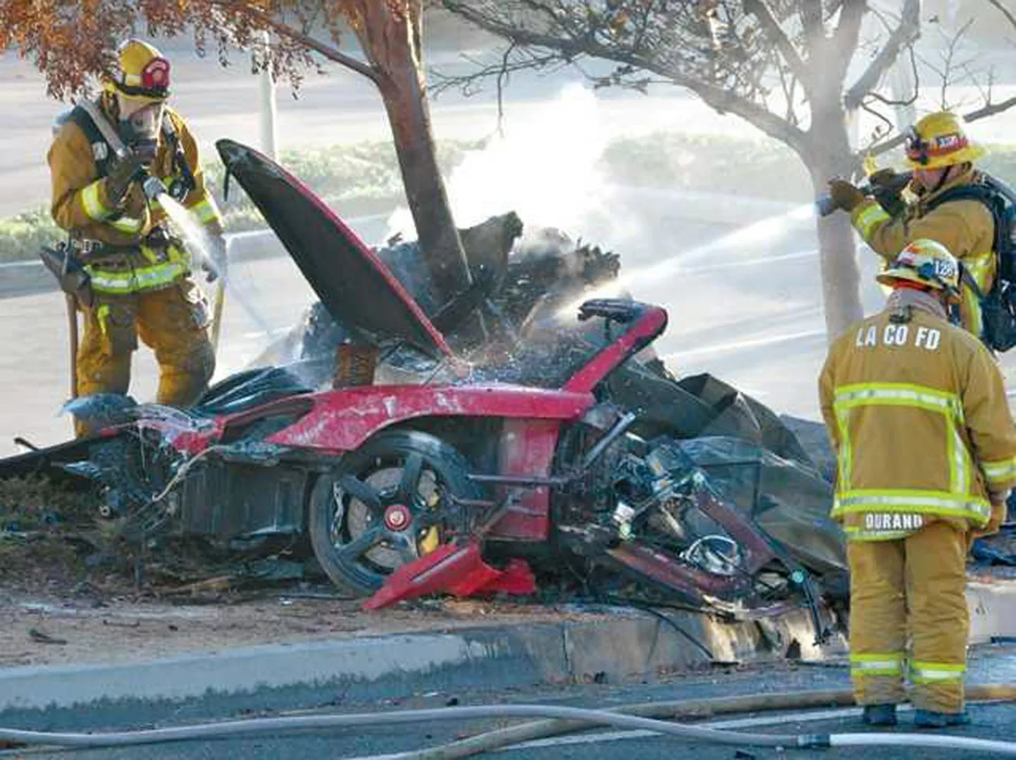 Tuletõrjujad kustutavad autot, millega tegid avarii Roger Rodas ja Paul Walker.