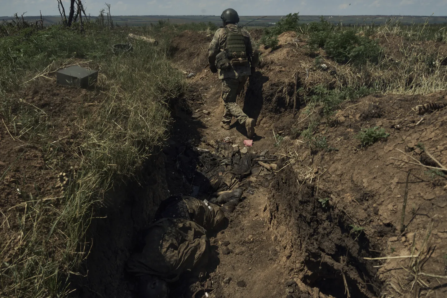 Ukrainas karavīrs staigā pa Krievijas armijas ierakumiem Bahmutā, kur ir okupantu līķi.