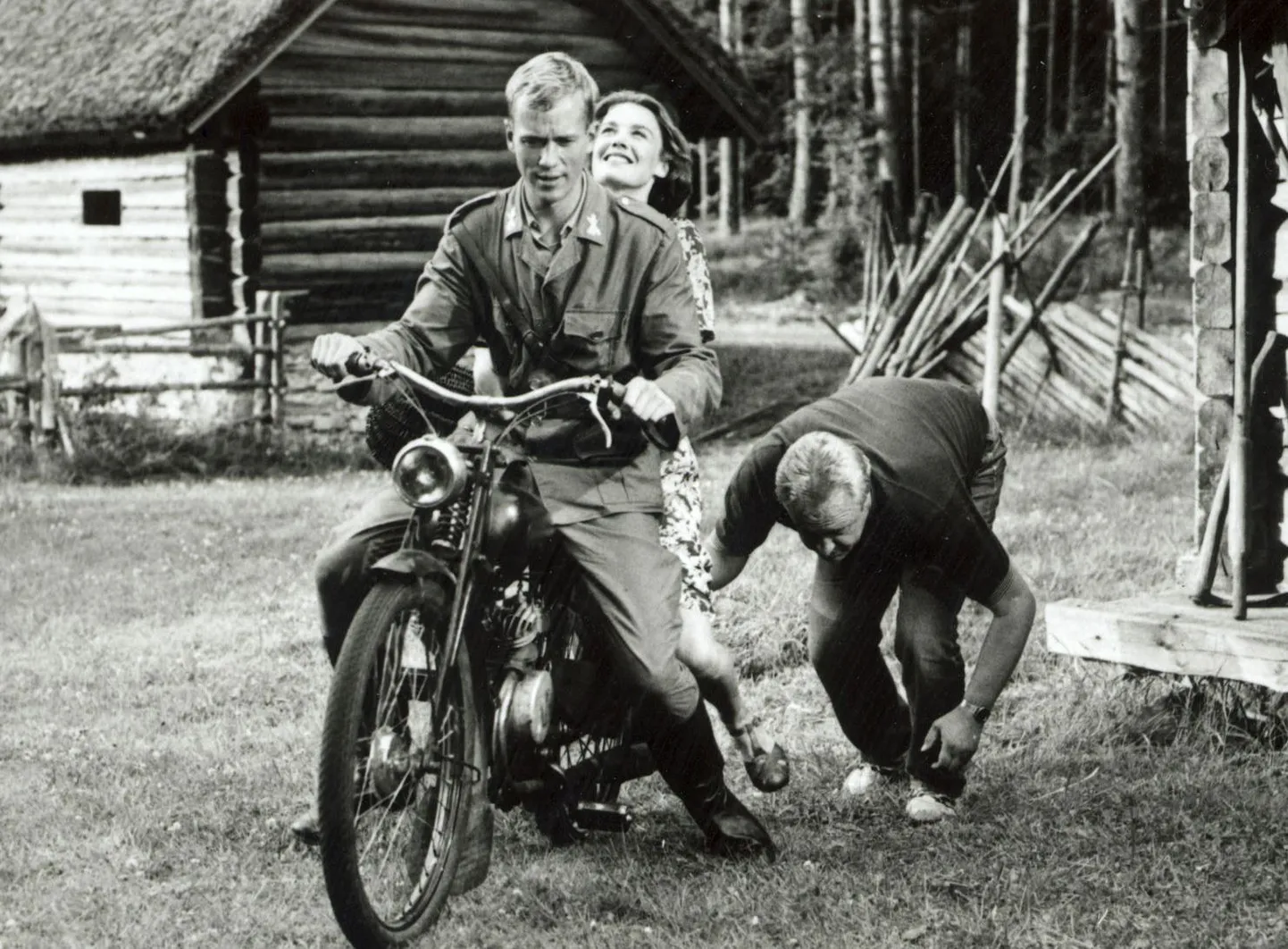 Foto Tulivesi (1994) võtetelt. Tsiklil Jaan Tätte ja Epp Eespäev, kummargil filmigrupi liige