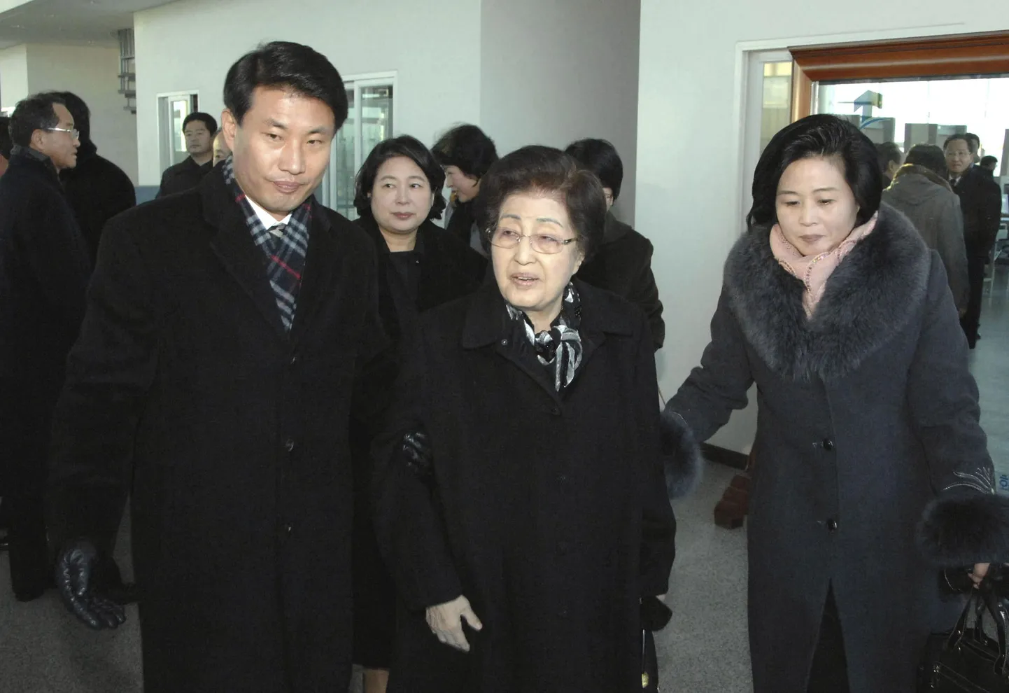 Former first lady Lee Hee-ho (C), widow of late South Korean President Kim Dae-jung and Hyundai Group chairwoman Hyun Jung-eun (2nd L, behind Lee) arrive in Pyongyang to pay their respects over North Korean leader Kim Jong-il's death December 26, 2011.   REUTERS/KCNA (NORTH KOREA - Tags: POLITICS OBITUARY) THIS IMAGE HAS BEEN SUPPLIED BY A THIRD PARTY. IT IS DISTRIBUTED, EXACTLY AS RECEIVED BY REUTERS, AS A SERVICE TO CLIENTS. NO THIRD PARTY SALES. NOT FOR USE BY REUTERS THIRD PARTY DISTRIBUTORS