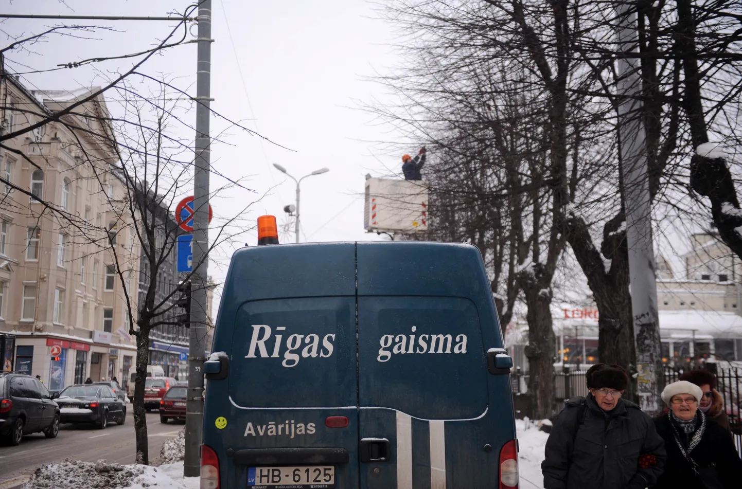 Rīgas pašvaldības aģentūras "Rīgas Gaisma" darbinieki izliek kokos Ziemassvētku lampiņas