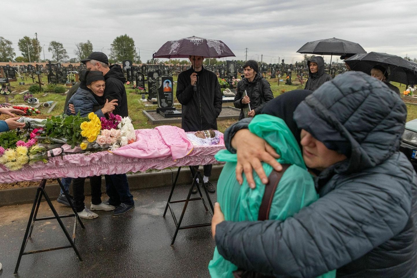 Прощание с Анастасией на 18-м кладбище в Харькове. Мать и отец поддерживают друг друга позади розового гроба.