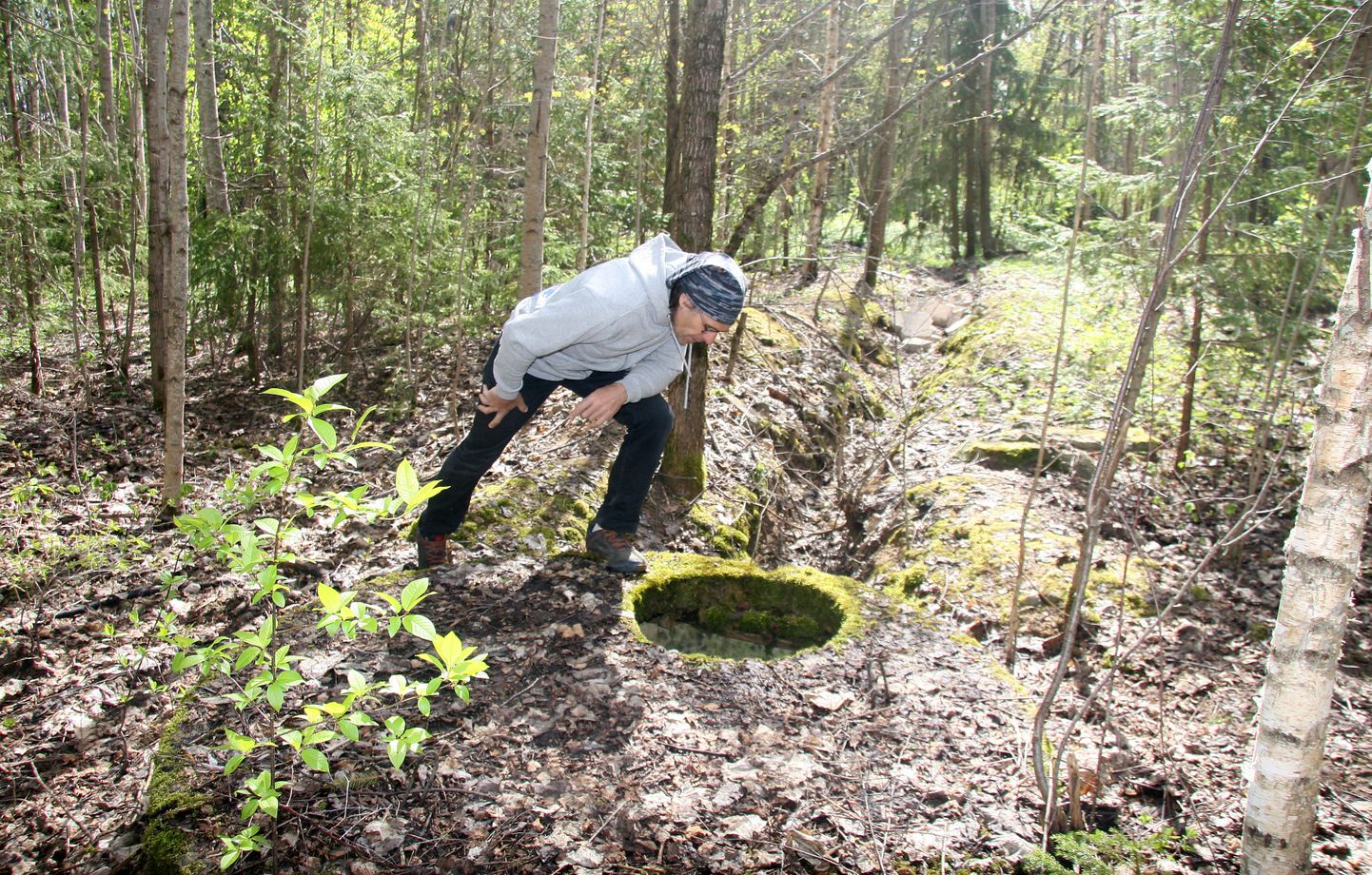 Priit Orav näitab üht metsa vahel olevat kaevu, millest turritavad kaablid annavad tunnistust, et siin oli kunagi isegi pump reovee transportimiseks, kuid mingit reovett siia ei jõua ja kaev on täiesti kuiv.