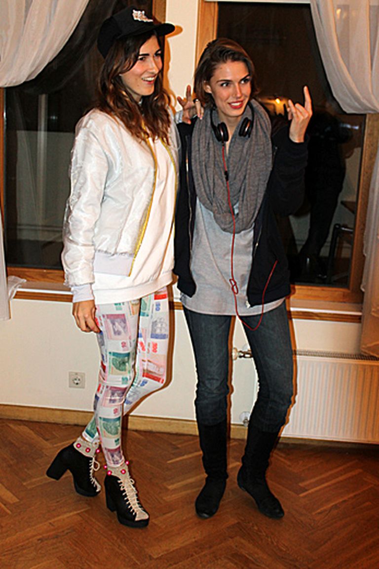 Modes māksliniece Aļona Bauska (no kreisās) tērpusies savas jaunākās kolekcijas legingos ar Latvijas latu apdruku, bet zīmola QooQoo biznesa vadītāja Anita Irbe izvēlējusies pašas radītu flīsa jaciņu 