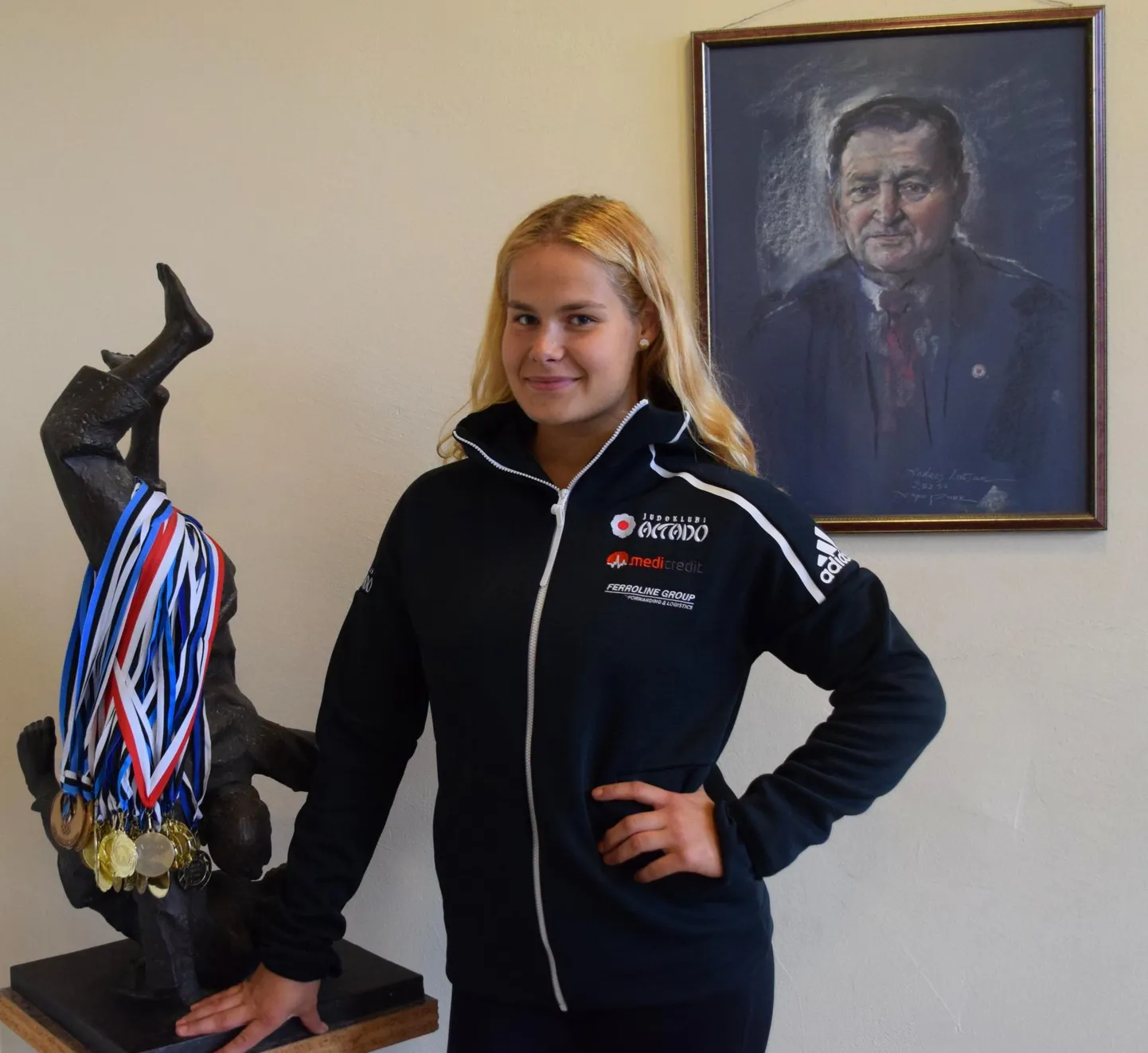 Naisjudoka Annika Karilaid poseerib Eesti judoisa Andres Lutsari portree taustal