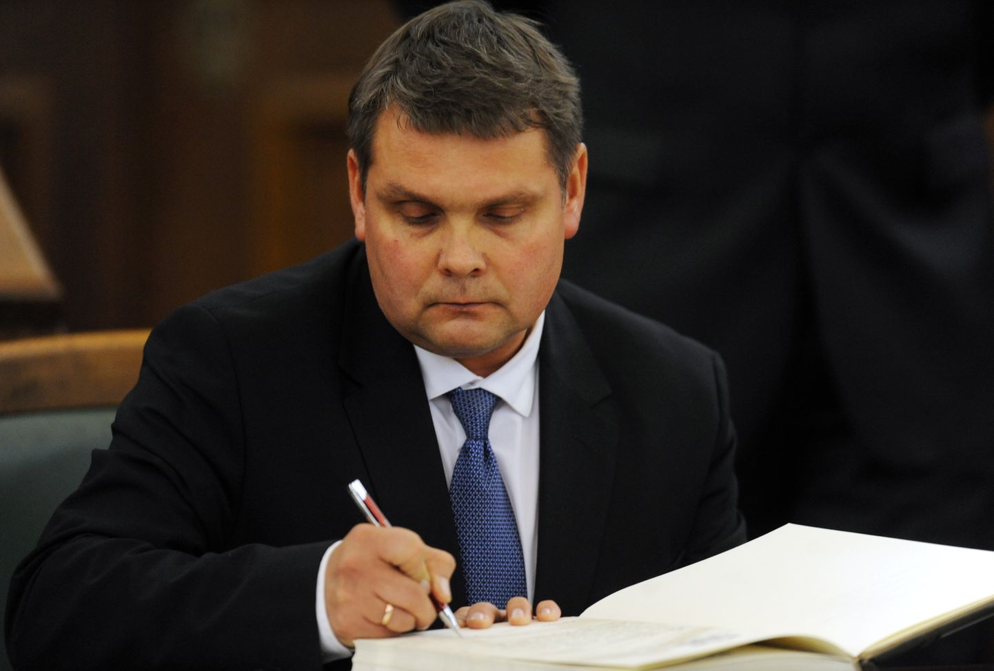 12.Saeimas deputāts Aldis Adamovičs svinīgo zvērestu jeb solījumu apliecina ar savu parakstu 12.Saeimas pirmajā sēdē.