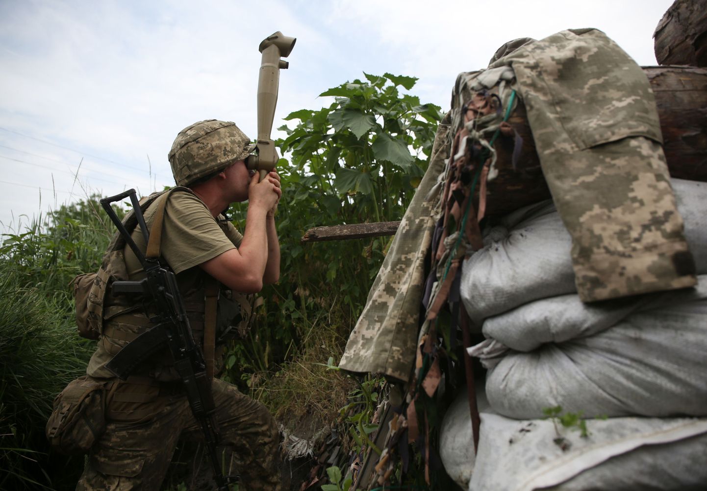 Ukrainas karavīrs vēro ienaidnieku frontes līnijas pozīcijā netālu no okupētās Doņeckas pilsētas, 2021. gada 24. jūnijā.