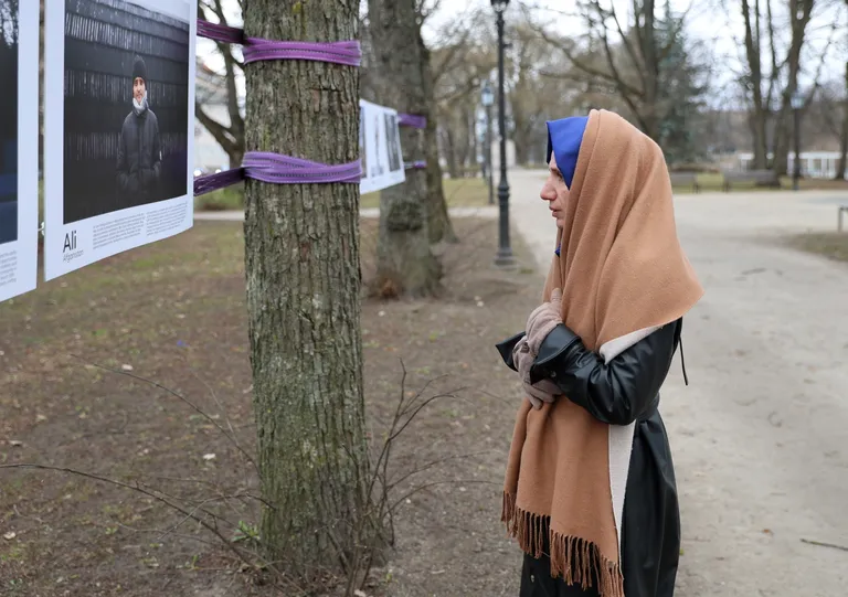 Sümeyra silmitseb portreenäitusel teiste saatusekaaslaste lugusid.