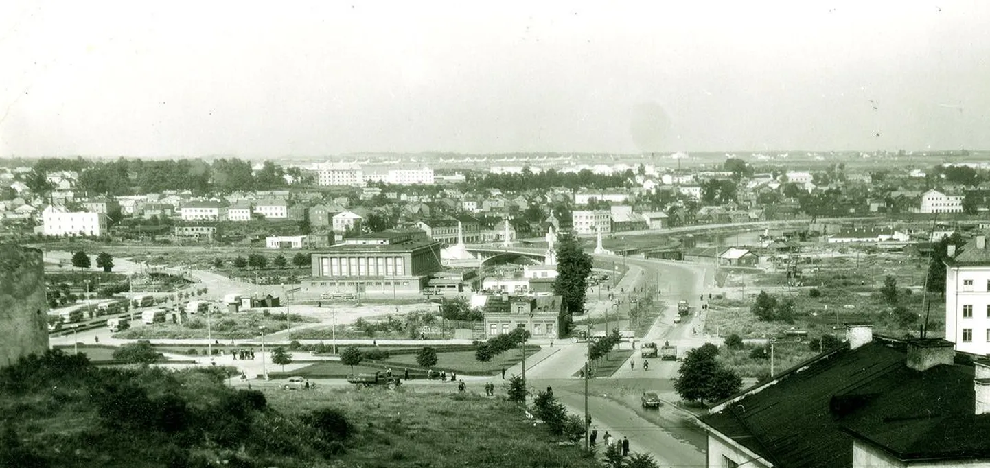 Vaade Ülejõele üle lageda kesklinna. Üleval troonivad ürgoru nõlvale kerkinud valged ohvitseride majad, taamal paistmas Raadi lennuvälja pommilennukid. On aasta 1957.
