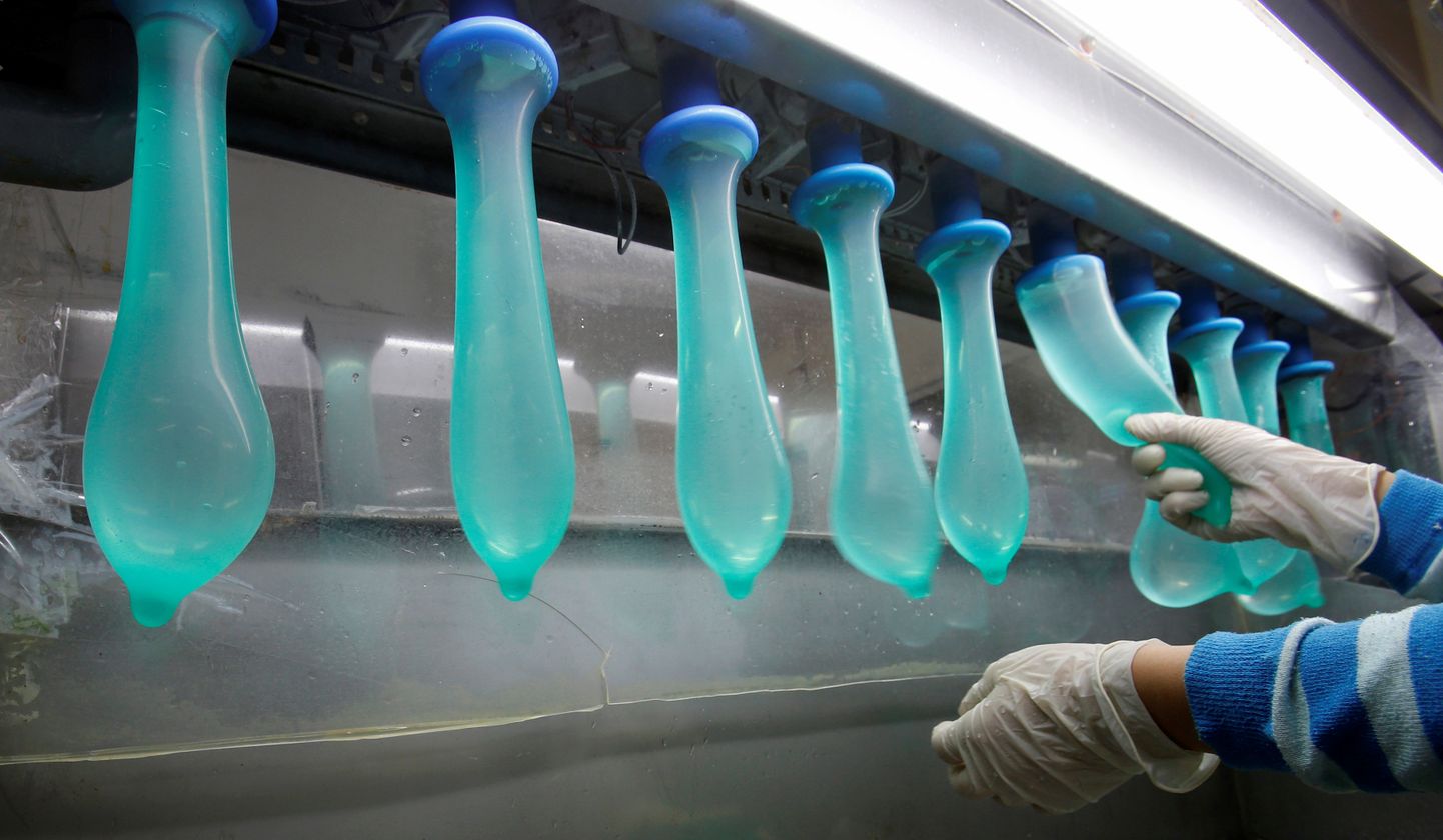 Работник тестирует изделие на производстве кондомов Karex в Малайзии