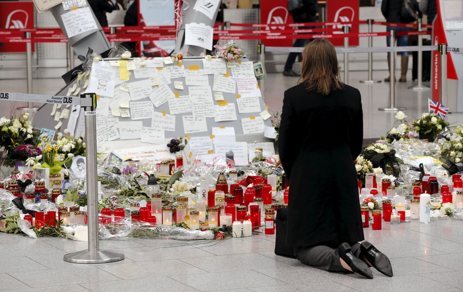 Naine põlvitab Düsseldorfi lennujaamas küünalde ja lillede juures, mis on toodud sinna Germanwingsi lennukatastroofi ohvrite mälestuseks.
