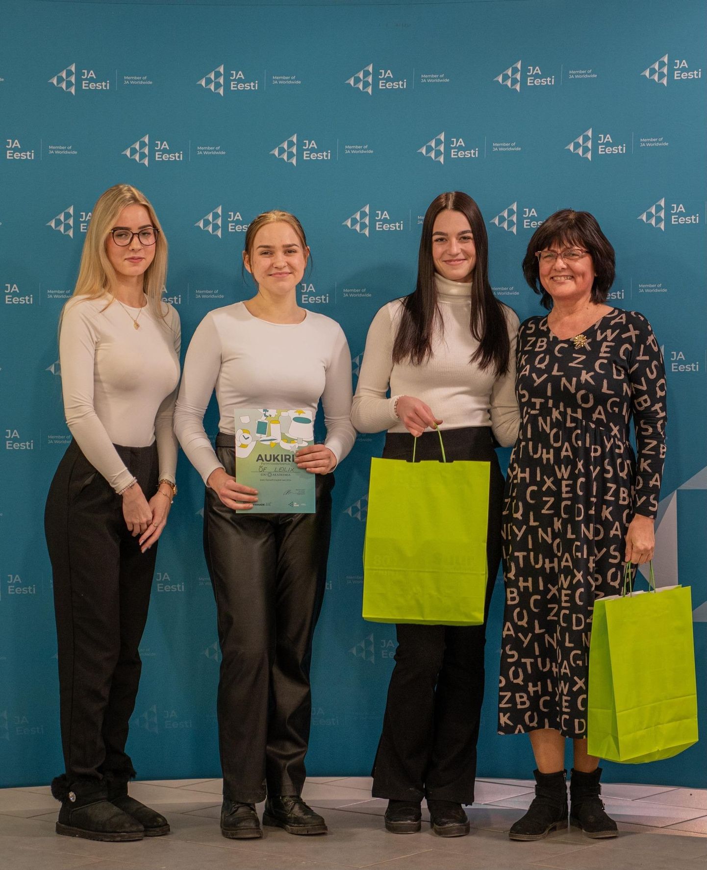 Õpilasfirma liikmed Paula Raudsaar (vasakult), Kadri Kruusmaa ja Heti-Helena Hindrikson ning juhendaja Kaia Tamm.