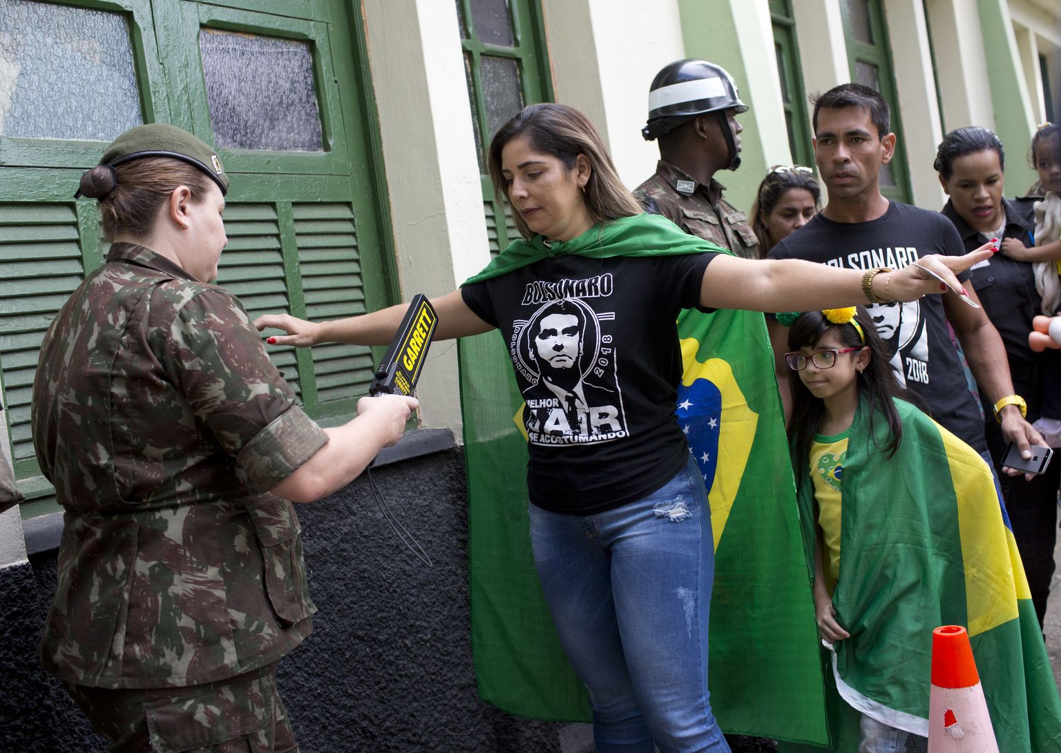 Jair Bolsonaro pildiga särke kandvad hääletajad järjekorras valimisjaoskonna juures Rio de Janeiros.