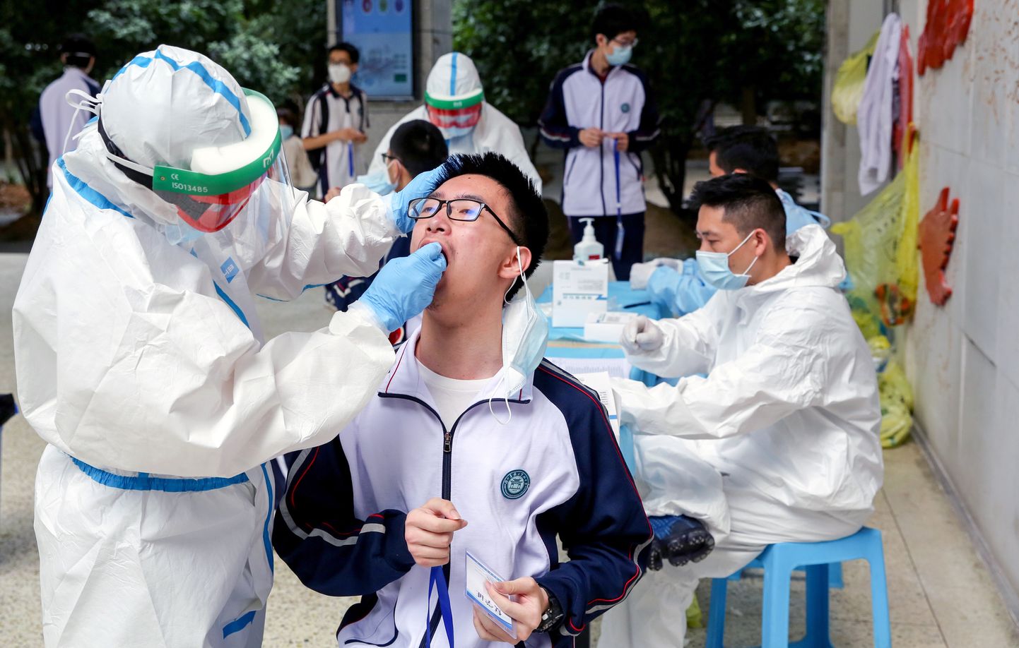 Kaitseriietes töötaja võtmas viiruseproovi Wuhani keskkooliõpilastelt, enne kui neil lubatakse naasta õppeasutusse.
